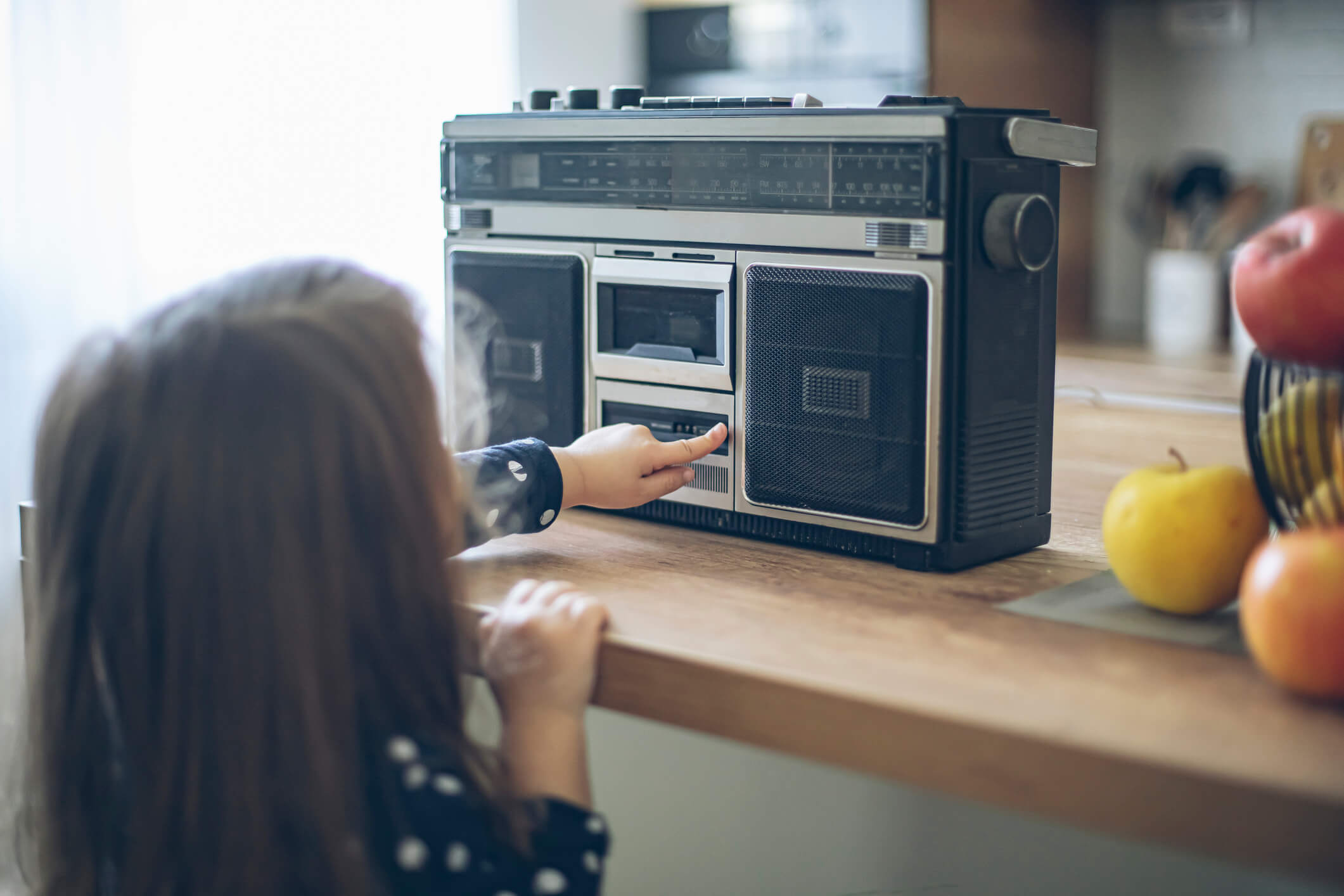 A little girl pointing at an old fashioned radio