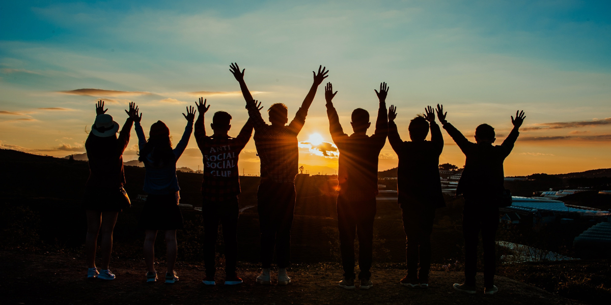 A group of people praising during sunrise