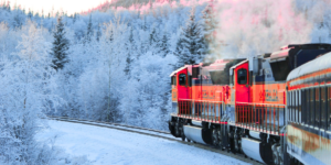 Red train traveling through a frosty forest